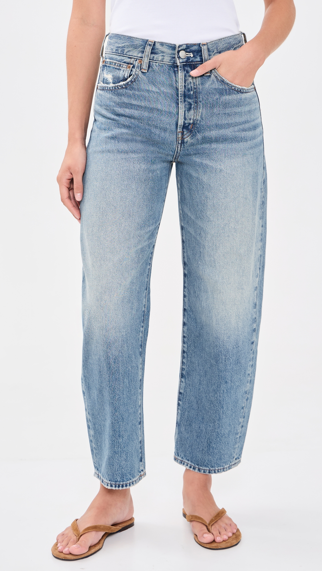 Medium-wash barrel-leg jeans shown at full length