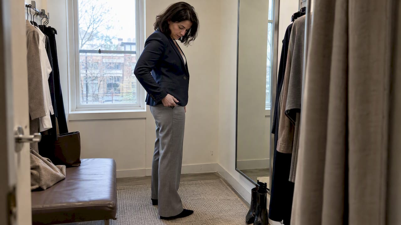 Woman checking a navy blazer with gray trousers